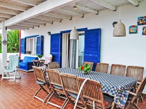 a dining room with blue shutters and a table and chairs at Villa Giulia by Interhome in Sperlonga