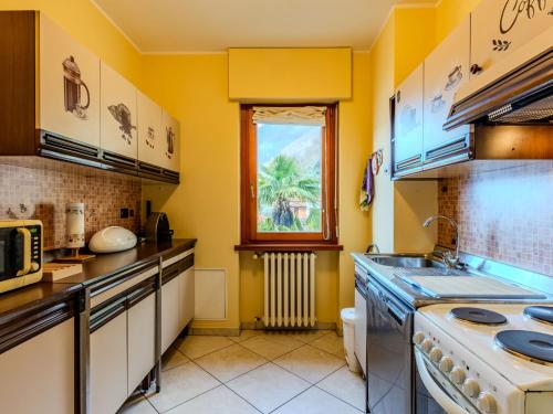 a kitchen with yellow walls and a sink at Apartment Miralago by Interhome in Oria