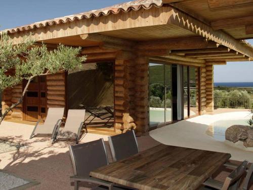 - un patio avec une table et des chaises en bois sous un pavillon dans l'établissement Holiday Home Stellu by Interhome, à Pietracorbara