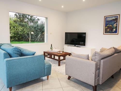 - un salon avec deux chaises et une télévision à écran plat dans l'établissement Holiday Home villa La Clarté by Interhome, à Perros-Guirec