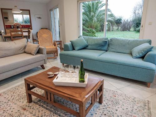 un salon avec un canapé bleu et une table dans l'établissement Holiday Home villa La Clarté by Interhome, à Perros-Guirec