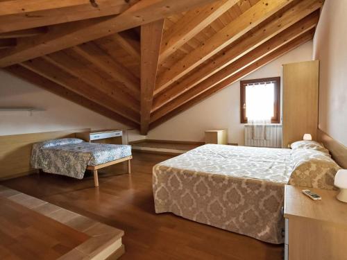 a bedroom with two beds and wooden ceilings at Apartment Solmare-52 by Interhome in Rosapineta