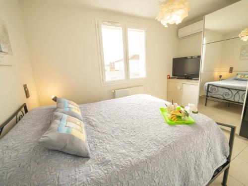 une chambre avec un lit avec un plateau dessus dans l'établissement Holiday Home Les Brigantines by Interhome, au Grau-du-Roi