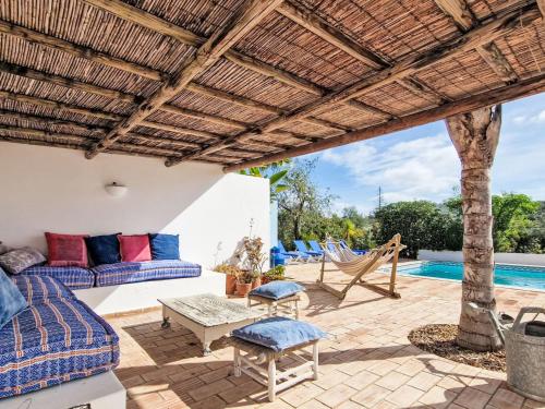 an outdoor patio with couches and a hammock at Holiday Home Romanzeira by Interhome in Moncarapacho
