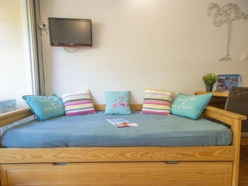 - un lit avec des oreillers et une télévision murale dans l'établissement Studio Escale Port-5 by Interhome, au Grau-du-Roi