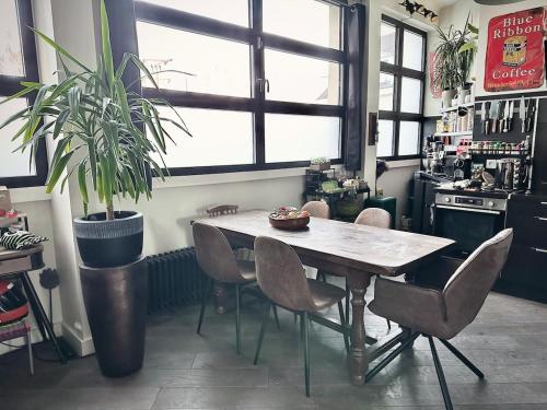 une table et des chaises dans une cuisine avec une plante en pot dans l'établissement Perfect Home to discover Paris in Peace with Love, à Paris