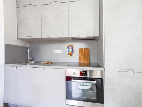 une cuisine avec une cuisinière et un évier dans l'établissement Apartment Le Palais du Vieux Port by Interhome, à Nice
