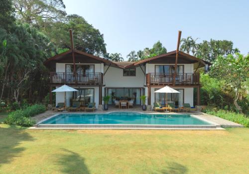 a villa with a swimming pool and a house at Barcelo Coconut Island, Phuket in Phuket Town