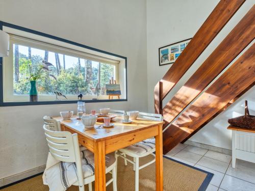 une salle à manger avec une table et des chaises en bois dans l'établissement Holiday Home Hameau du golf-7 by Interhome, à Lacanau-Océan