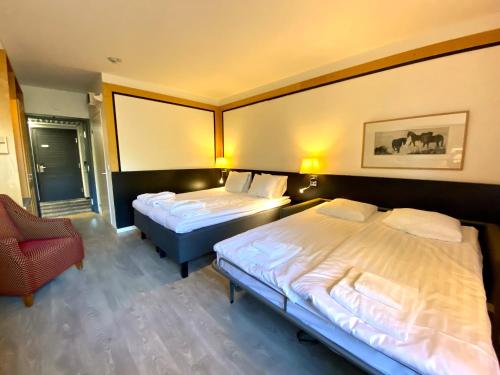 a hotel room with two beds and a chair at Hotel Korpilampi in Espoo