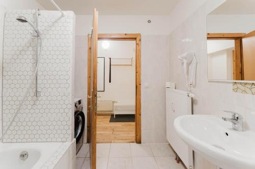 a white bathroom with a shower and a sink at feworld living - Wasserwald Linz in Linz
