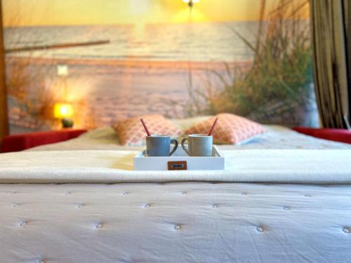 un lit avec deux tasses dessus dans l'établissement Studio Le Trianon by Interhome, à Arcachon