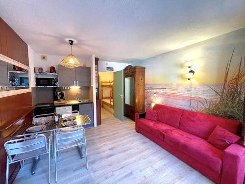 un salon avec un canapé rouge et une cuisine dans l'établissement Studio Le Trianon by Interhome, à Arcachon