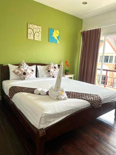 a bedroom with a bed with a stuffed animal on it at Sea Boss Homestay in Kata Beach