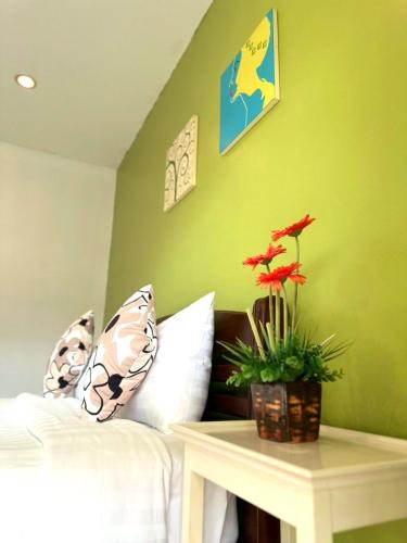 a bedroom with a bed and a table with a plant at Sea Boss Homestay in Kata Beach