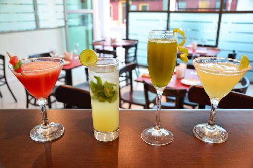 three drinks in glasses sitting on a table at Hotel Del Rio in Constitución