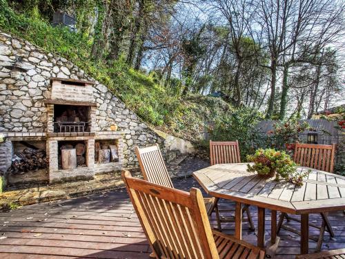 une table et des chaises en bois avec une cheminée en pierre dans l'établissement Villa Villa Bellevue by Interhome, à Saint-Paul-de-Vence