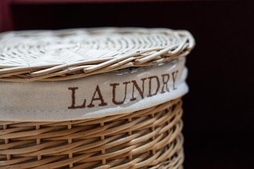 a wicker basket with the word laundry written on it at Earthbound Guest House in Oudtshoorn