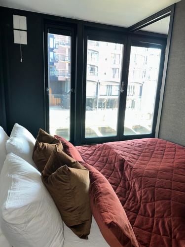 un letto con cuscini in una stanza con finestra di Exclusive Apartment at Tjuvholmen ,Luxury in the Heart of Oslo a Oslo