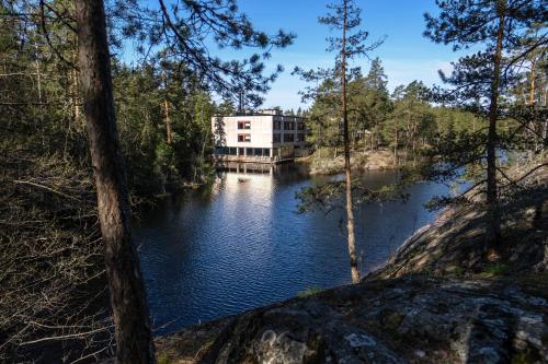 a building sitting on the side of a body of water at Hotel Korpilampi in Espoo