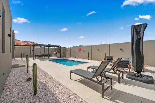 a patio with chairs and a swimming pool at Safir 40 in Palm-Eagle Beach