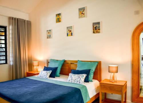 a bedroom with a bed with blue sheets and pillows at Cottage for Couples with Pool, BBQ and views in Tamarin