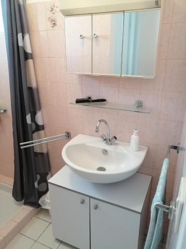 une salle de bain avec un lavabo blanc et une douche dans l'établissement Maison Ile de Ré, à Sainte-Marie de Ré