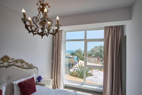 een slaapkamer met een bed en een groot raam bij Anda Apartment Spa Pool beach resort in Mamaia