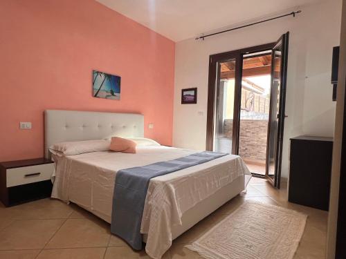 a bedroom with a bed and a large window at Dalia House - Key to Villas in Valledoria