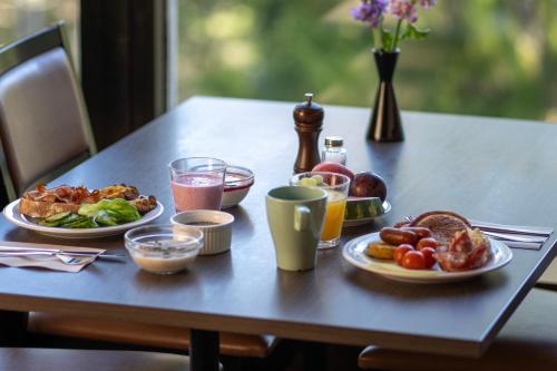 a table with plates of food and drinks on it at Hotel Korpilampi in Espoo