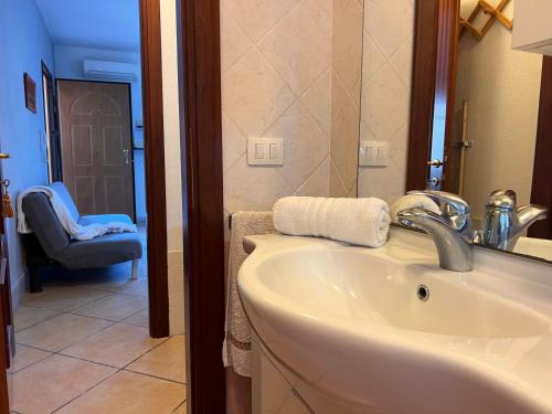 a bathroom with a sink and a mirror and a chair at Dalia House - Key to Villas in Valledoria