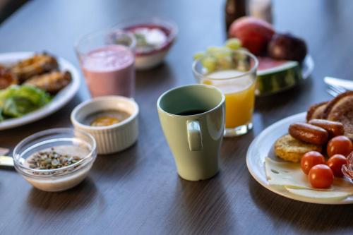 a table with a plate of food and a cup of coffee at Hotel Korpilampi in Espoo