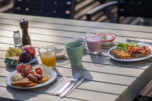 a table with plates of food and drinks on it at Hotel Korpilampi in Espoo