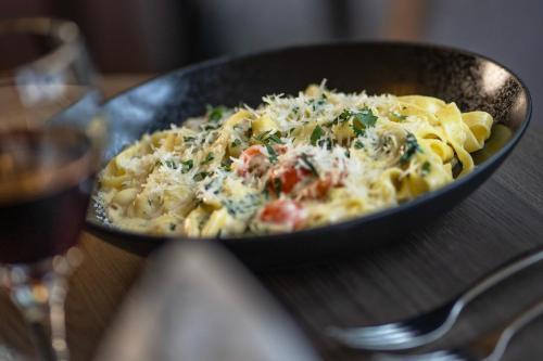 a pasta dish in a pan on a table at Hotel Korpilampi in Espoo