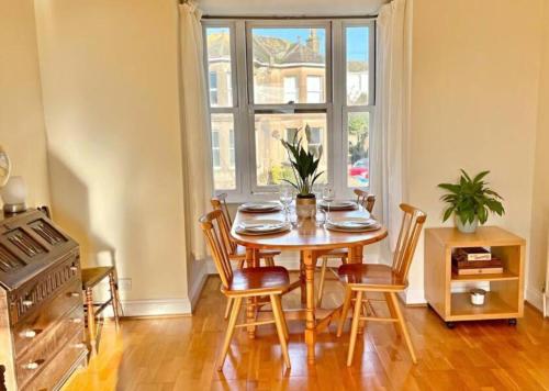 ein Esszimmer mit Tisch und Stühlen und einem Fenster in der Unterkunft Kanangra, 2 bedroom apartment in Teignmouth in Teignmouth