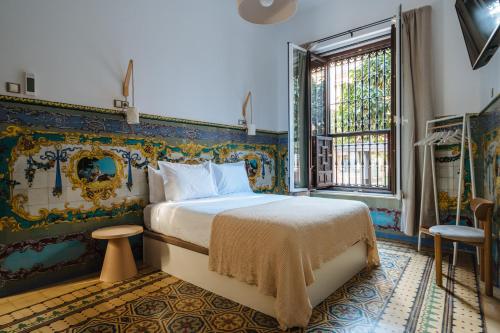 a bedroom with a king sized bed in a room at Apartamentos "El Escondite de Triana" in Seville
