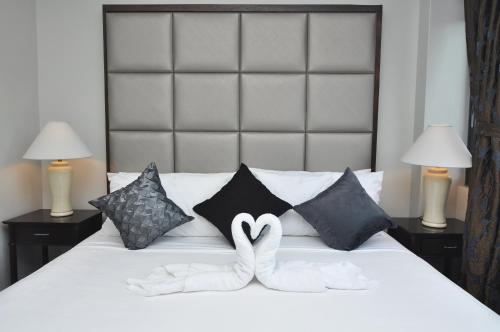 a bed with two white towels in the shape of hearts at 717 Cesar Place Hotel in Tagbilaran City