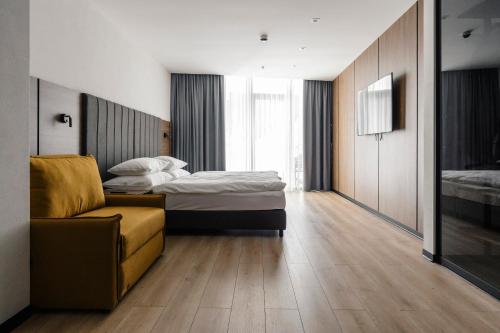 a hotel room with two beds and a couch at Mountain Residence Wellness & SPA in Bukovel