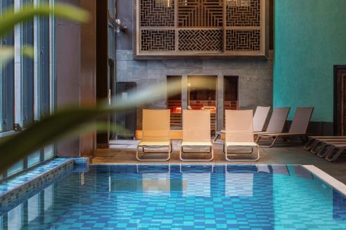a pool with lounge chairs and a fireplace at Hilton Evian Les Bains in Évian-les-Bains