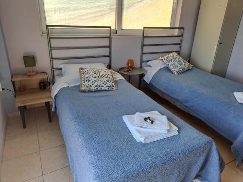 a bedroom with two beds with towels on them at Seashell Apartment in Artemida