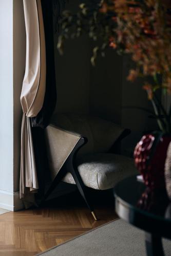 a chair in a living room next to a window at Palazzo del Corso – Boutique Hotel in Gallipoli