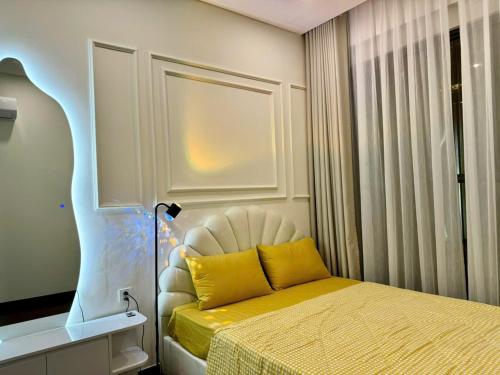 a bedroom with a bed with a yellow pillow at Căn Hộ 2 Phòng ngủ LUXURY-1516 in Gia Lâm Pho