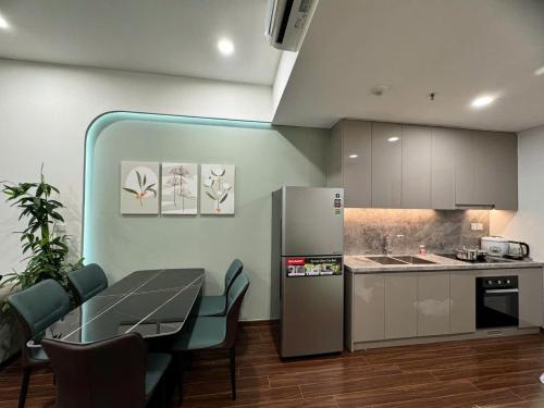 a kitchen with a table and a refrigerator in a room at Căn Hộ 2 Phòng ngủ LUXURY-1516 in Gia Lâm Pho