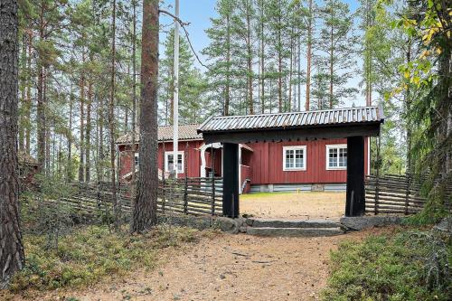 a red house in the middle of a forest at Nice ski in ski out cabin in Bollnäs