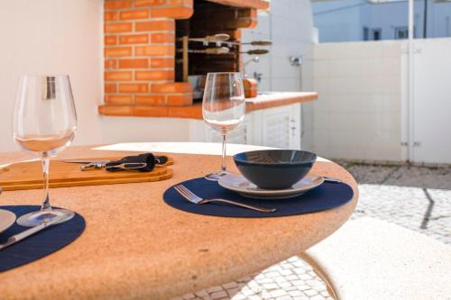 a table with two wine glasses and a bowl on it at TAC - Serenity Manta Rota in Vila Nova De Cacela