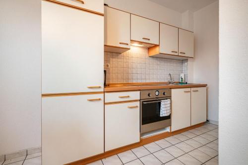 a kitchen with white cabinets and a stove at Kolbatzer Mühle in Lychen