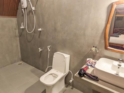 a bathroom with a toilet and a sink at Sigiri Choona Lodge 'unique sunrise viewpoint' in Sigiriya