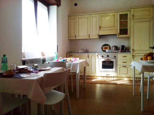 cocina con armarios blancos, mesa y sillas en B&B Anna Fiera, en Verona