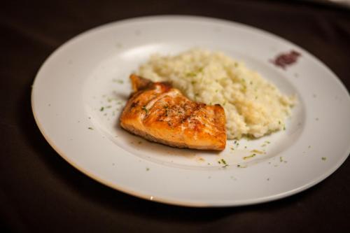a white plate with a piece of fish and mashed potatoes at Casas Novas Countryside Hotel Spa & Events in Chaves