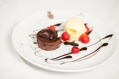 a chocolate dessert with strawberries and ice cream on a plate at Casas Novas Countryside Hotel Spa & Events in Chaves